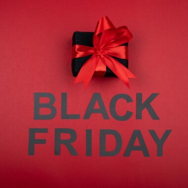 Black gift box with red ribbon, perfect for Black Friday sales promotions.