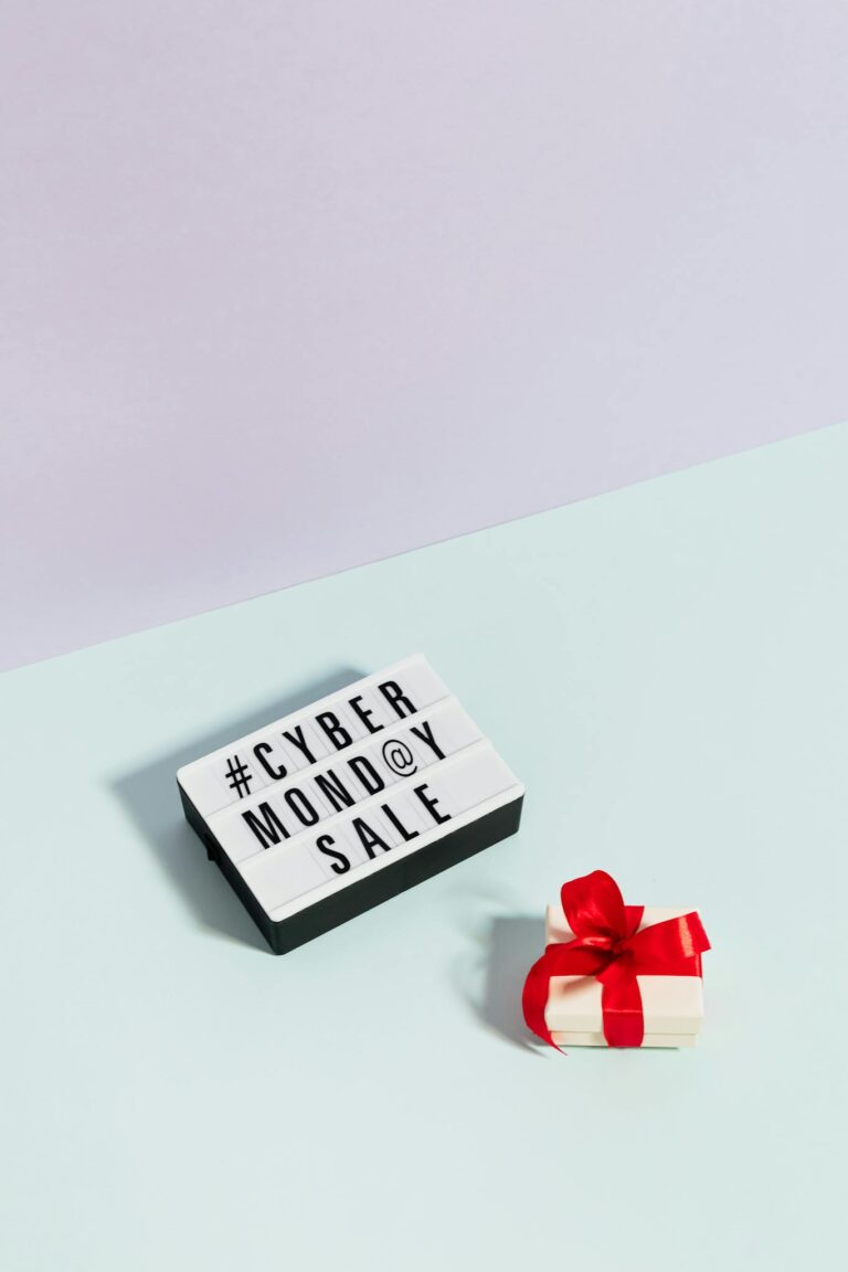 Minimalist setup showing a Cyber Monday sale sign and a gift box with a red bow.
